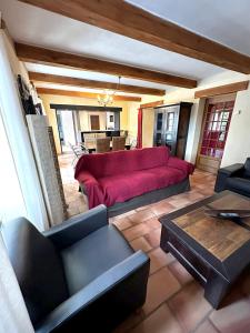 a living room with a red couch and a table at Villa élégante à Méjannes-lès-Alès avec piscine privée in Méjannes-lès-Alès