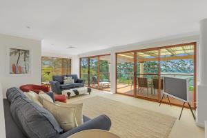 a living room with a couch and a tv at Orion Beach Retreat in Vincentia