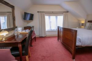 a hotel room with a bed and a desk and a table at Weston Hall Hotel Sure Hotel Collection by Best Western in Bulkington