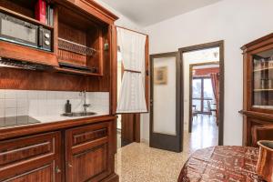 a kitchen with wooden cabinets and a sink at ANGOLO ALLA STAZIONE SUITE - Appartamento con terrazzo panoramico in Pavia