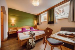 a bedroom with two beds and a table and a chair at Hotel Lisa in Flachau