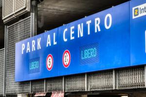 a blue sign that reads park all centro at ANGOLO ALLA STAZIONE SUITE - Appartamento con terrazzo panoramico in Pavia