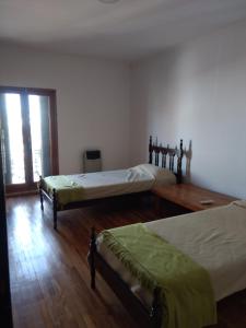 1 dormitorio con 2 camas y suelo de madera en Departamento Rocamora en Concepción del Uruguay