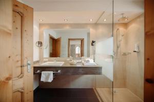 ein Badezimmer mit Waschbecken und Dusche in der Unterkunft Hotel Lisa in Flachau