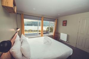 a bedroom with a bed with a large window at Boreland Loch Tay in Aberfeldy