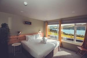 a bedroom with a large bed and a large window at Boreland Loch Tay in Aberfeldy
