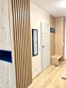 Cette chambre est dotée d'un mur en bois et d'une porte. dans l'établissement Platon Residence Apartments, à Łódź