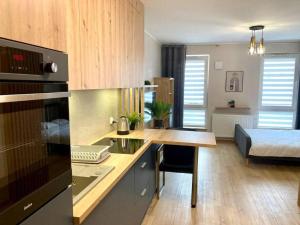 - une cuisine avec un bureau et un lit dans une chambre dans l'établissement Platon Residence Apartments, à Łódź