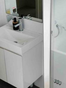 a bathroom with a white sink and a mirror at 2Bedrooms 2Bathrooms Oasis in Parramatta w parking in Sydney