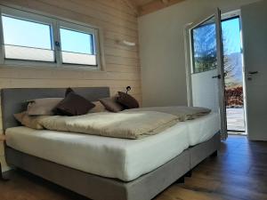 Landhaus Zeitlos في هايمباخ: سرير كبير في غرفة بها نوافذ