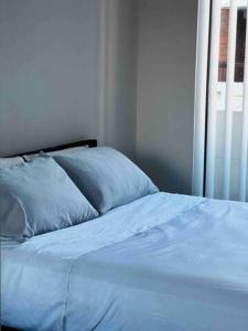1 cama con almohadas azules en una habitación con ventana en 2Bedrooms 2Bathrooms Oasis in Parramatta w parking, en Sídney