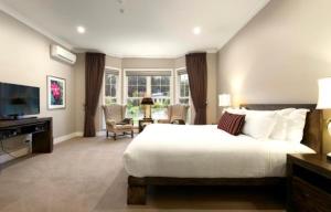 Kerami Manor & Day Spa في ماريسفيل: غرفة نوم بسرير كبير وغرفة معيشة