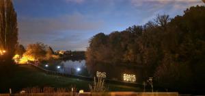 uma vista para um lago à noite com luzes em Darkwolf House em Merseburg