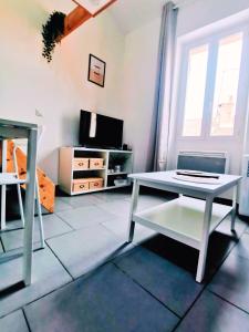 Una sala de estar con una mesa y un televisor. en Le Cocon, en Toulon