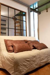 un letto con cuscini marroni sopra di Farris & Cors Casa Sansiro a Genova