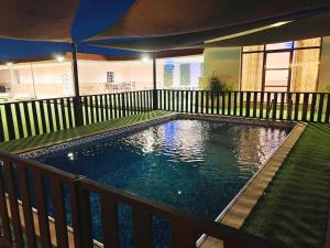 a swimming pool on a deck with an umbrella at Labella Chalet in Barka