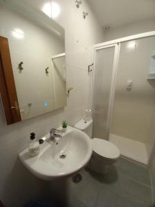 Baño blanco con lavabo y aseo en Casa Margarida, en Allariz
