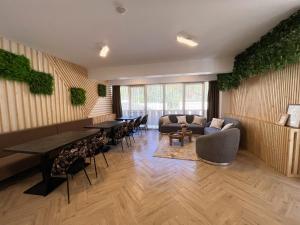 Casa Forrest & SPA في Muntele Săcelului: غرفة معيشة مع أريكة وطاولات وكراسي