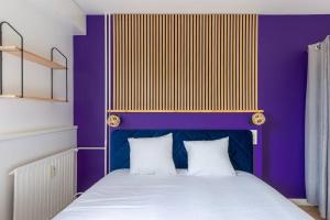 um quarto roxo com uma cama com 2 almofadas brancas em Le club green - appt 45 m2 - 4P - parking em Metz