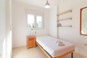 Un pat sau paturi într-o cameră la Global Properties, Apartamento de 3 dormitorios y terraza en la playa de Canet