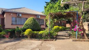 a house with a garden in front of it at Quest in Lilongwe