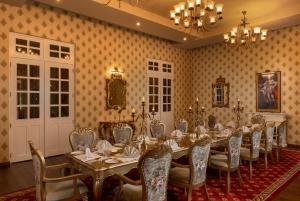 una grande sala da pranzo con un lungo tavolo e sedie di The Westbury Palace a Nuwara Eliya