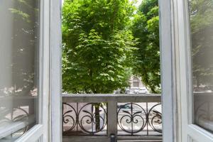 una ventana abierta con vistas a un árbol desde el balcón en B&B Le Grazie, en Bérgamo