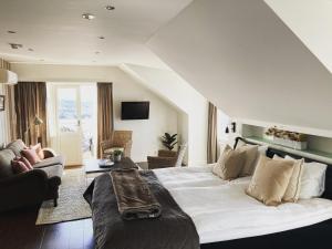 a bedroom with a large bed and a living room at Grand Hôtel Mölle in Mölle