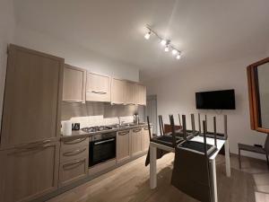 a kitchen with white cabinets and a table and a television at MARTA'S APARTMENT ROCCARASO in Roccaraso