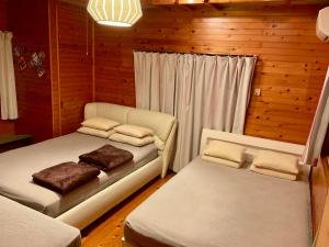 a bedroom with two beds in a wooden room at ゆーみー. in Meinohama