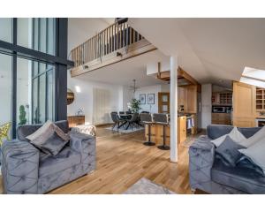 a living room with two couches and a kitchen at Central Belfast Apartments Pottinger's Quay in Belfast