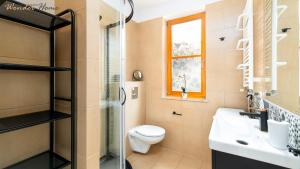 une salle de bain avec toilettes, lavabo et fenêtre dans l'établissement Wonder Home - Domek Karkonosz z kominkiem i dwoma sypialniami - tuż przy stoku Myśliwska 42-1, à Karpacz