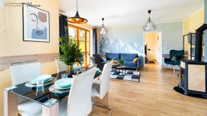une salle à manger et un salon avec une table et des chaises dans l'établissement Wonder Home - Domek Karkonosz z kominkiem i dwoma sypialniami - tuż przy stoku Myśliwska 42-1, à Karpacz