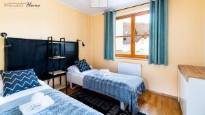 une chambre avec deux lits et une fenêtre dans l'établissement Wonder Home - Domek Karkonosz z kominkiem i dwoma sypialniami - tuż przy stoku Myśliwska 42-1, à Karpacz