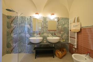 a bathroom with two sinks and two mirrors at Muri Vecchi in Marina dʼAndora