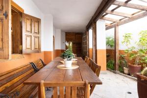 drewniany stół i ławki w pokoju z roślinami w obiekcie Casa Argelia w mieście Vilaflor