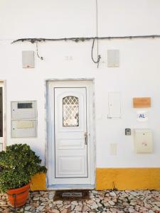 a white door on a white wall with a plant at Casa Morgado by NaturAlegre in Alegrete