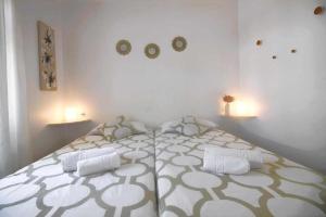 a white bedroom with a large bed in a room at Nautic Apartment in Puerto del Carmen in Tías