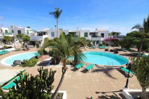 a resort with a swimming pool and palm trees at Nautic Apartment in Puerto del Carmen in Tías