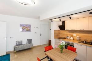 Una cocina y un comedor con mesa y sillas. en Peter Pan lodge - 15min walk to Disney, en Chessy