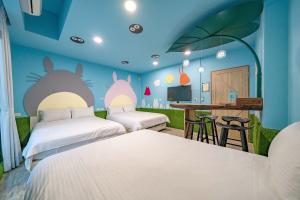 a bedroom with two beds and a table with a bar at 精彩奇寓站前電梯主題民宿走路到車站好停車 in Hualien City +55 photos