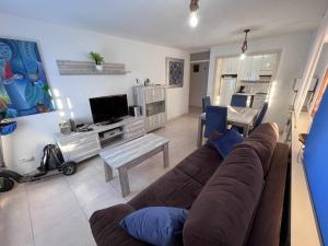 sala de estar con sofá marrón y mesa en Apartamento con terraza en San Juan Playa, en Alicante