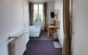 Habitación con cama y escritorio con ordenador. en Hôtel Michelet Plage en Soulac-sur-Mer
