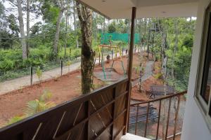 - un balcon offrant une vue sur une aire de jeux dans l'établissement Munnar ethan's valley, à Anachal