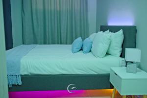 1 dormitorio con 1 cama con almohadas azules y blancas en Rinkase residence, en Pretoria