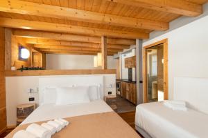 Duas camas num quarto com tectos em madeira em Locanda dei cantù em Carona