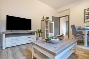 ein Wohnzimmer mit einem TV und einem Couchtisch in der Unterkunft Sanierter Wohntraum in Linden in Hannover
