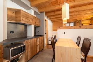 a kitchen with a wooden table and a dining room at Locanda dei cantù in Carona