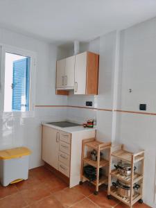 a kitchen with white walls and wooden cabinets at Pita 2 in La Isleta del Moro