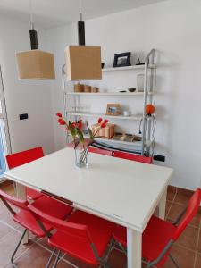 una mesa blanca con sillas rojas en una habitación en Pita 2, en La Isleta del Moro 8 fotos más